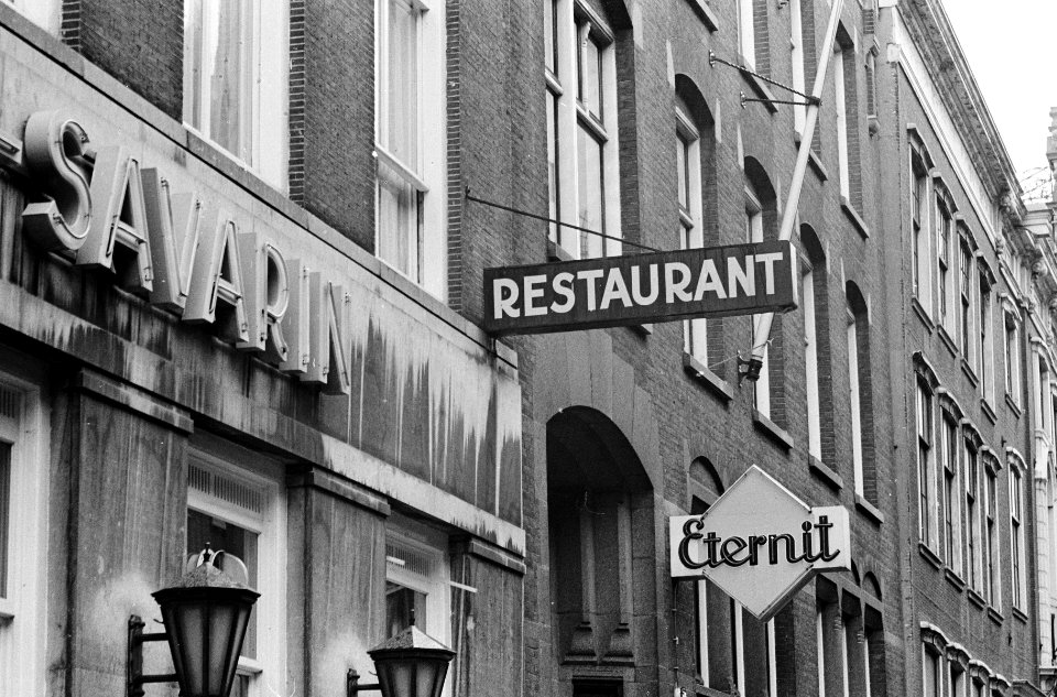 Uithangborden in Amsterdam Restaurant met daaronder bord Eternit (eet er niet), Bestanddeelnr 915-7609