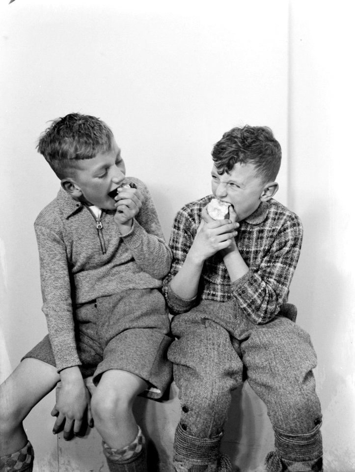 V.l.n.r. Harry en Herman zitten op een kruk en eten een appel, Bestanddeelnr 189-1100