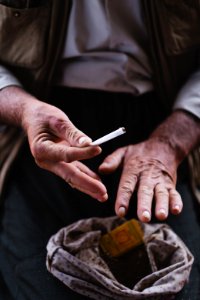 Views in June of 2019 of an Ezidi man in Sardashte Camp for displaced Ezidis rolling a cigarette with tobacco grown nearby atop Shingal mountain 36