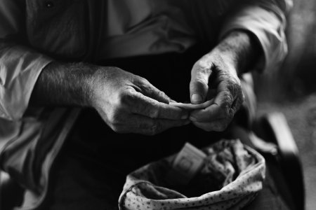 Views in June of 2019 of an Ezidi man in Sardashte Camp for displaced Ezidis rolling a cigarette with tobacco grown nearby atop Shingal mountain 16
