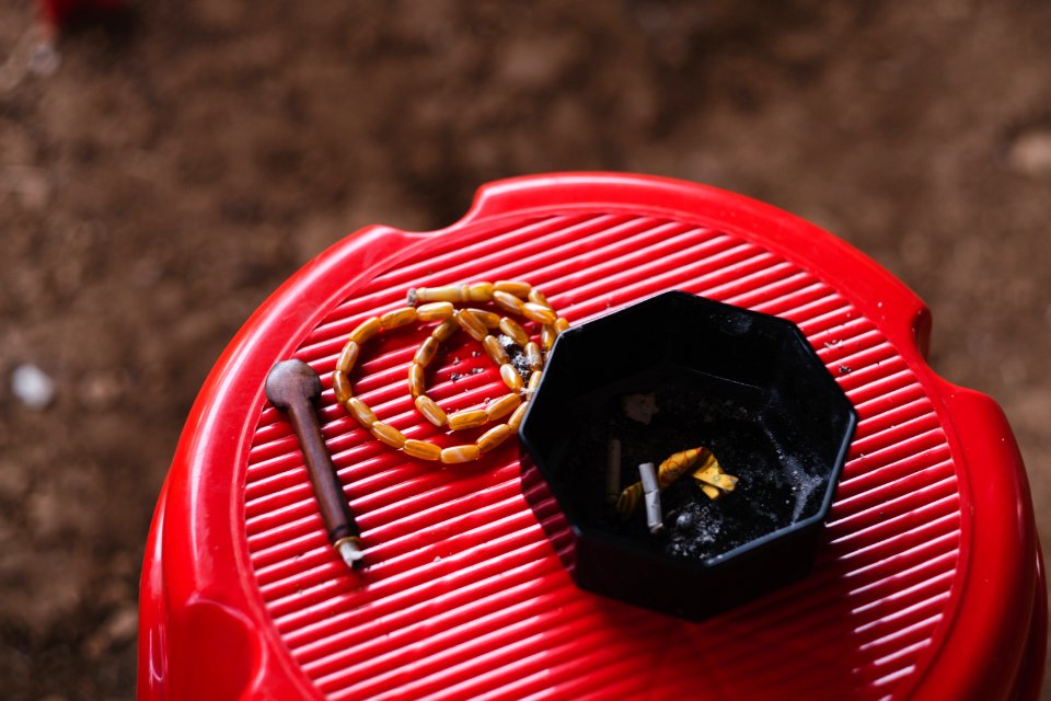 Views in June of 2019 of an Ezidi man in Sardashte Camp for displaced Ezidis rolling a cigarette with tobacco grown nearby atop Shingal mountain 27