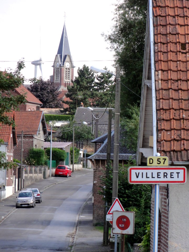 Villeret (Aisne) main street, city limit sign, church, wind turbine