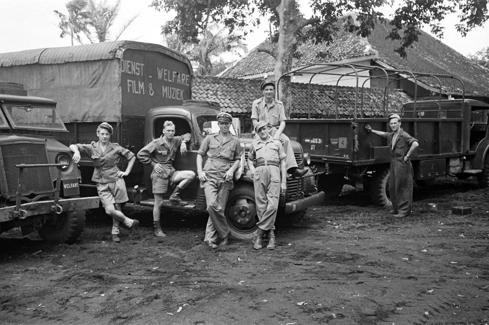 Vijf militairen poseren bij een truck van de dienst Welfare Film en Muziek, Bestanddeelnr 177-4-2