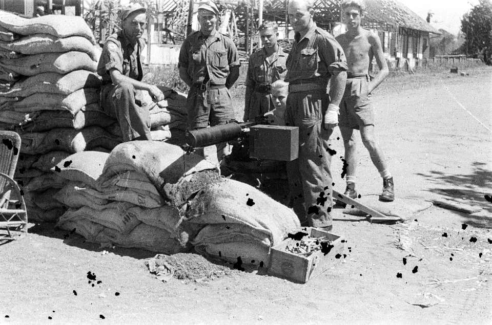 Vijf militairen bij een zwaar machinegeweer type Vickers achter een stapel zandz, Bestanddeelnr 7145