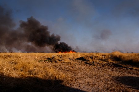 Views of the site of a massacre by the Islamic State and mass grave of Ezidis in Shingal (Sinjar) in summer of 2019 as field fires approach the location 01