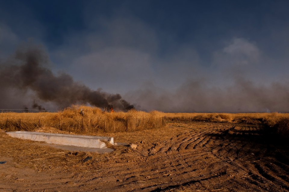 Views of the site of a massacre by the Islamic State and mass grave of Ezidis in Shingal (Sinjar) in summer of 2019 as field fires approach the location 11