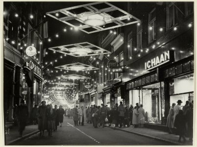 Verlichte en versierde Barteljorisstraat bij avond. NL-HlmNHA 54004648
