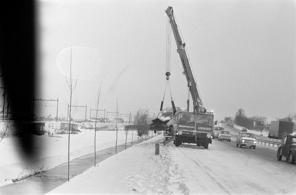 Verkeer op buitenwegen in de sneeuw. Kraanwagen haalt auto weg, Bestanddeelnr 923-2647
