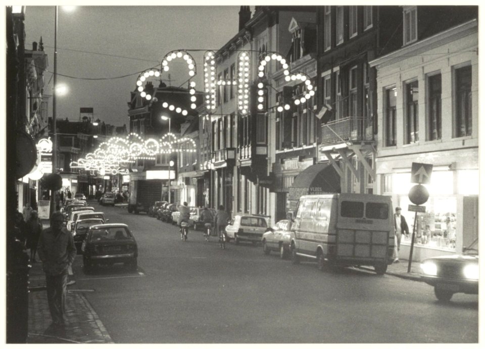 Verlichte Kruisstraat bij avond. NL-HlmNHA 54206555