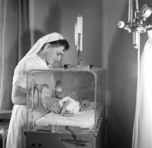 Verpleegster bij te vroeg geboren baby Martin in een couveuse, vermoedelijk in h, Bestanddeelnr 254-2527