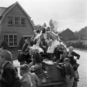 Verpleegsters en kinderen beklimmen een pantserwagen, Bestanddeelnr 900-2843