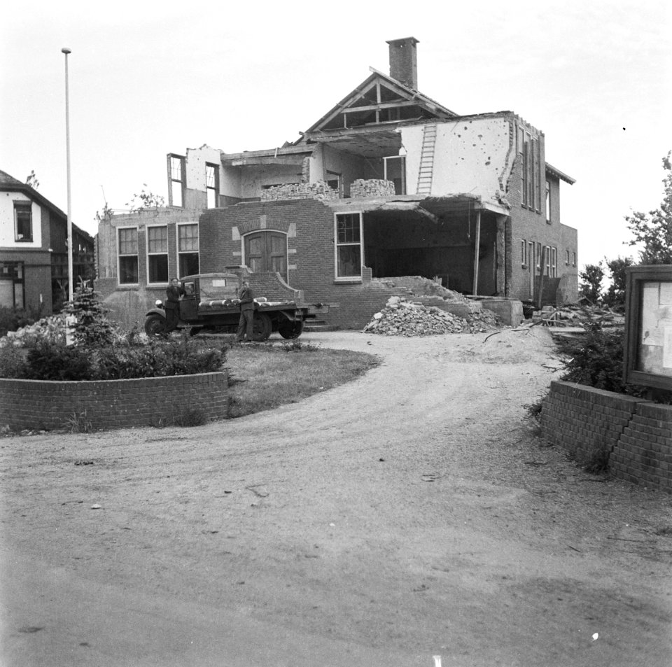 Verwoest gebouw, op de oprit een truck met dakbedekking, Bestanddeelnr 900-5202