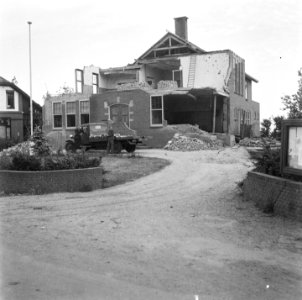 Verwoest gebouw, op de oprit een truck met dakbedekking, Bestanddeelnr 900-5202