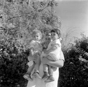 Verzorgster van de kinderopvang van kibboets Kiwath Brenner met twee peuters op , Bestanddeelnr 255-0572 photo