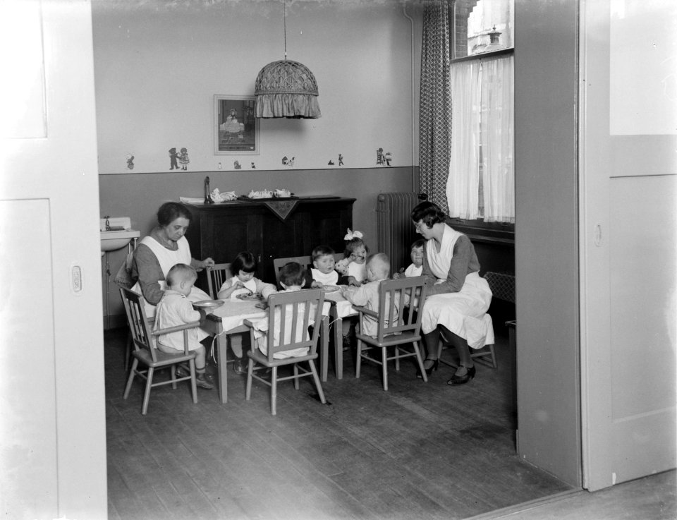 Verzorgsters van het tehuis Annette - in uniform en schort - helpen de peuters b, Bestanddeelnr 252-0381
