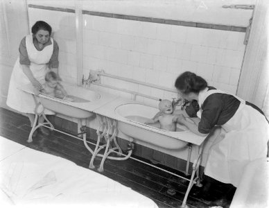 Verzorgsters van het kindertehuis doen twee peuters in bad, Bestanddeelnr 252-0388