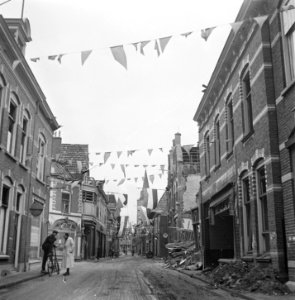 Versierde straat met rechts een verwoest pand (in het Gooi), Bestanddeelnr 900-2897