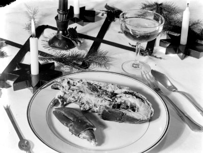 Versierde tafel gedekt voor het diner met op het bord een halve kreeft en een gl, Bestanddeelnr 189-1116