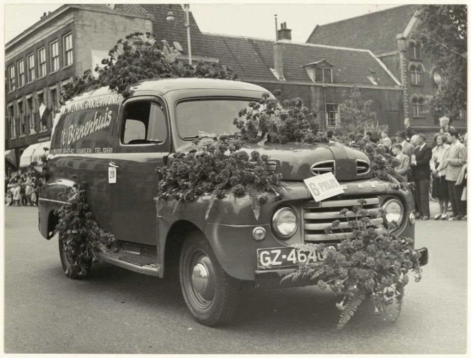 Versierde auto bij het jaarlijkse bloemencorso op de Grote Houtbrug. NL-HlmNHA 54010469