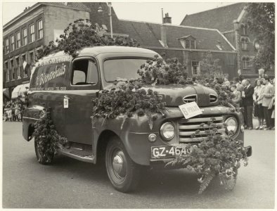 Versierde auto bij het jaarlijkse bloemencorso op de Grote Houtbrug. NL-HlmNHA 54010469