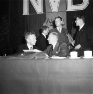 Vergadering van de Nederlandse Volksbeweging (NVB). Achter de bestuurstafel is …, Bestanddeelnr 900-7752