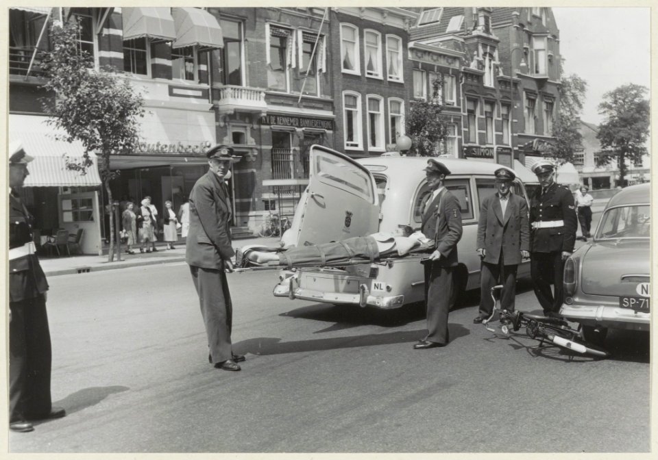 Verkeersongeval op het Houtplein. Het slachtoffer wordt per ambulance afgevoerd. NL-HlmNHA 54004795