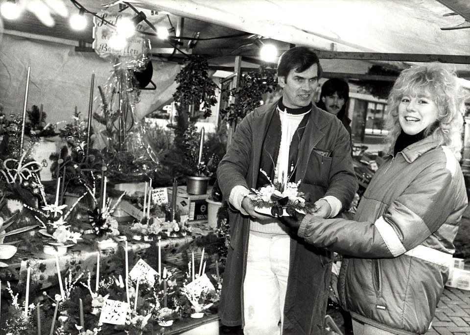 Verkoop van kerststukjes op de Botermarkt, bloemenstal van Leo van Norde. Aangekocht in 1988 van United Photos de Boer bv. - Negatiefnummer 28490 k 9 a. - Gepubliceerd in het Haarlems Dagblad van 15.1