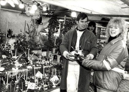 Verkoop van kerststukjes op de Botermarkt, bloemenstal van Leo van Norde. Aangekocht in 1988 van United Photos de Boer bv. - Negatiefnummer 28490 k 9 a. - Gepubliceerd in het Haarlems Dagblad van 15.1