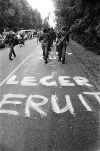 Vierdaagse Nijmegen, 3e dag soldaten wandelen over weg met protestleuzen tegen , Bestanddeelnr 929-8258