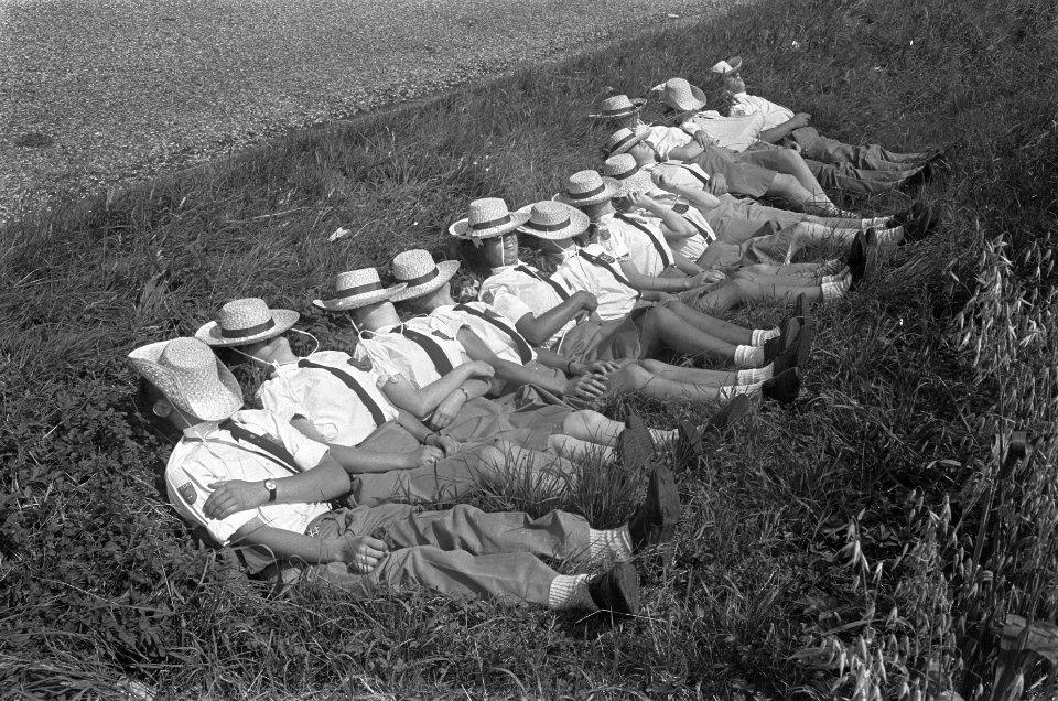Vierdaagse Apeldoorn. Groepje rust uit. Gezichten bedekt met strohoed tegen de z, Bestanddeelnr 920-5125