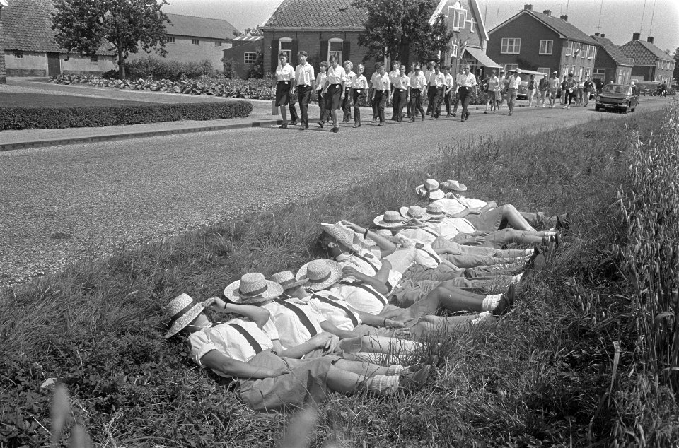 Vierdaagse Apeldoorn. Groepje rust uit. Gezichten bedekt met strohoed tegen de z, Bestanddeelnr 920-5128