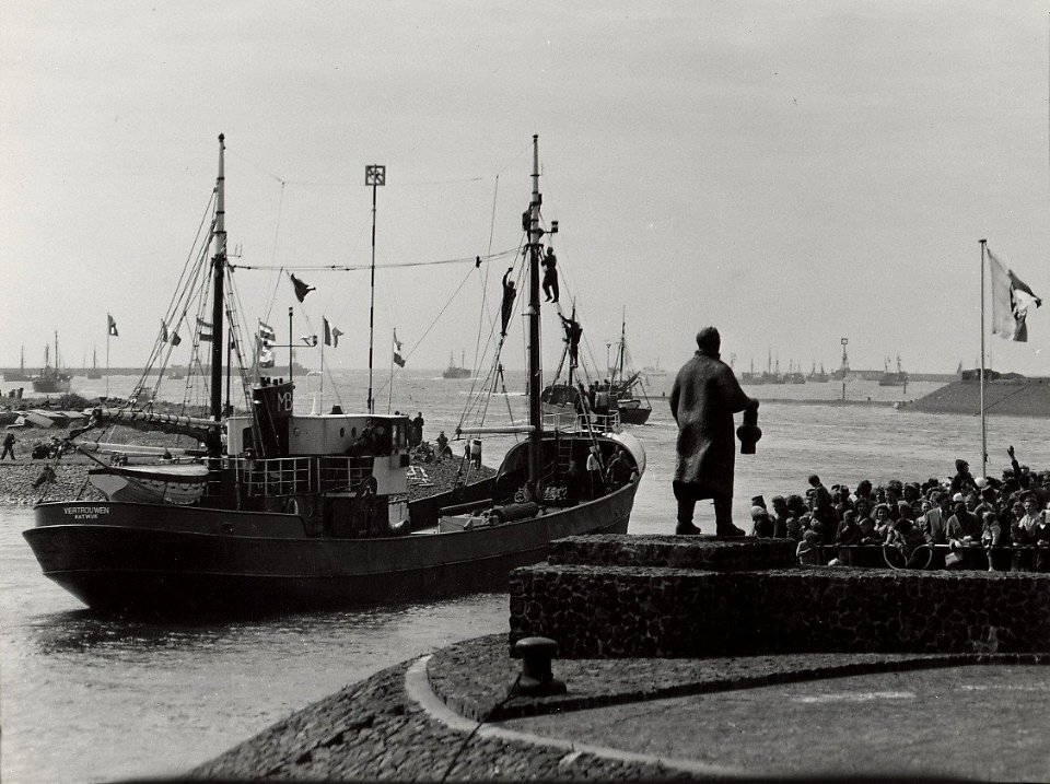 Vertrek van de vissersvloot uit de haven, om de jacht op de nieuwe haring te openen. Aangekocht in 1977 van fotograaf C. de Boer. Identificatienummer 54-005546