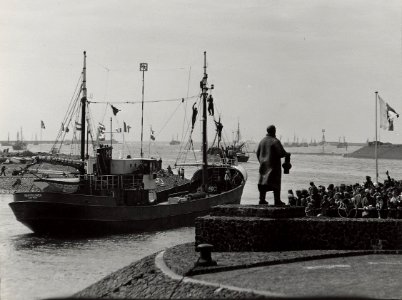Vertrek van de vissersvloot uit de haven, om de jacht op de nieuwe haring te openen. Aangekocht in 1977 van fotograaf C. de Boer. Identificatienummer 54-005546