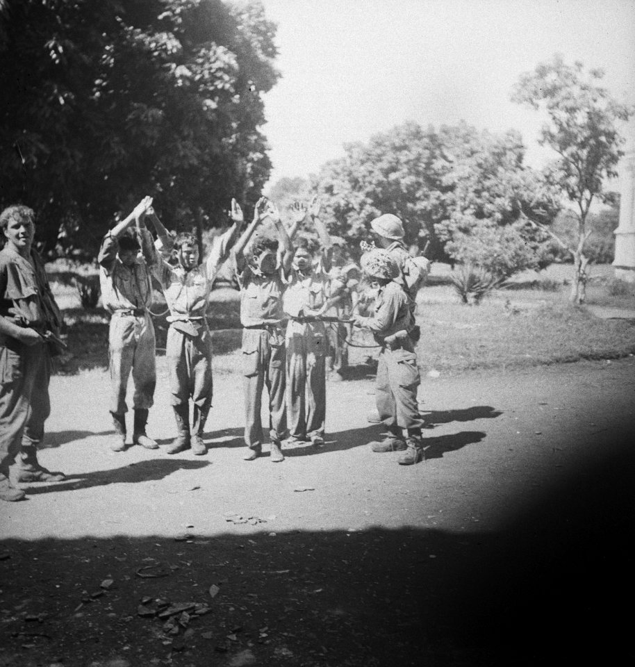 Vier Indonesische jonge mannen staan met de armen omhoog. Ze worden onder schot, Bestanddeelnr 15741
