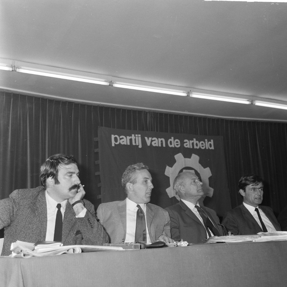 Vier leden van het partijbestuur, zittend aan de bestuurstafel Van der Louw, Kl, Bestanddeelnr 921-7018