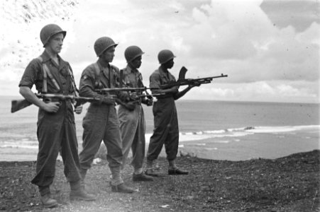 Vier militairen poseren met wapens bij de zee, Bestanddeelnr 163-4-2