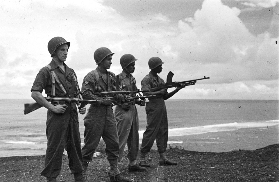 Vier militairen poseren met wapens bij de zee, Bestanddeelnr 163-4-3