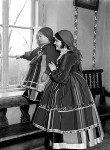 Vrouw en meisje in klederdracht kijken uit het raam in Lowicz, Bestanddeelnr 252-1290