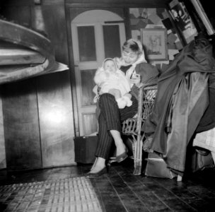Vrouw met een baby op schoot aan boord van het schip Siegfried & Erik te Parijs, Bestanddeelnr 252-9430