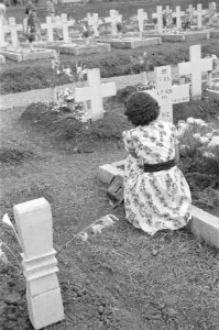 Vrouw legt bloemen op het graf van A.F. Kok, kpl I-R.S. overleden 14-11-1947, Bestanddeelnr 483-3-4