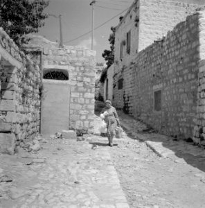 Vrouw met boodschappen in een straatje in Safad (Safed) met links een deur met e, Bestanddeelnr 255-4001 photo