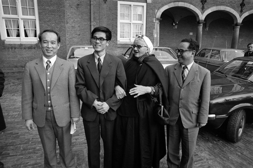 Vrouw in Scheveningse klederdracht gearmd met de Chinese diplomaat Kao geflankee, Bestanddeelnr 931-3006