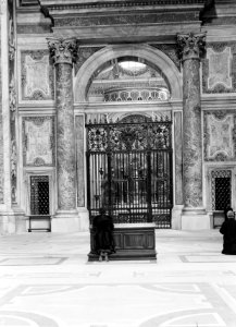 Vrouw geknield voor de toegang tot de sacramentskapel in de Sint-Pietersbasiliek, Bestanddeelnr 191-1250