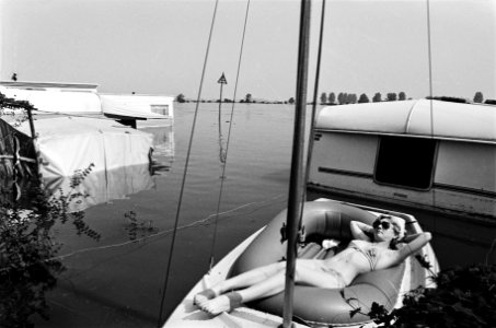 Vrouw in een bootje op een ondergelopen camping, Bestanddeelnr 930-9377