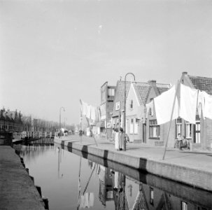 Vrouw in klederdracht op straat bij de waslijn, Bestanddeelnr 254-3603