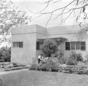 Vrouw aan het werk in de voortuin van een woonhuis, Bestanddeelnr 255-0143