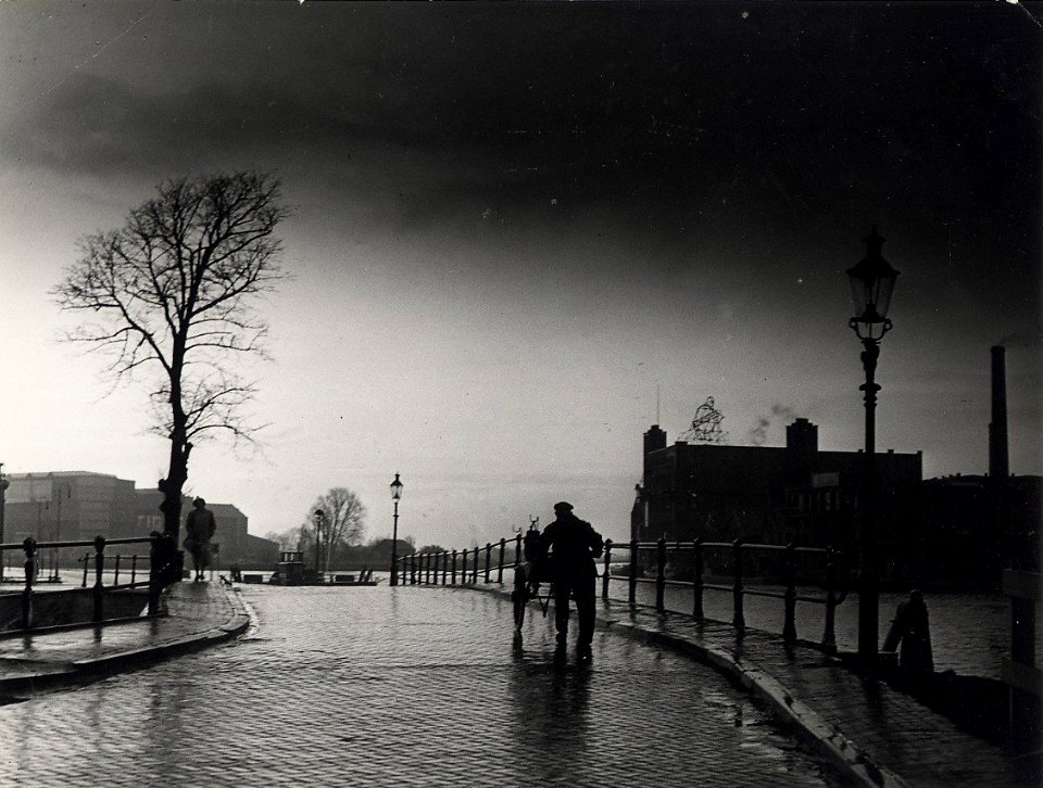Vrouwebrug, over de Kloppersingel en de zuid-westzijde van de cacao- en chocoladefabriek van de firma Droste. Aangekocht in 1977 van fotograaf C. de Boer. Identificatienummer 54-004327, NL-HlmNHA 54004327