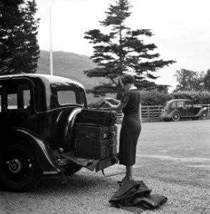 Vrouw bindt koffers achterop de auto, Bestanddeelnr 254-2818 photo
