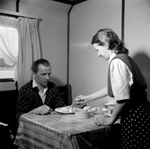 Vrouw van de tweede machinist dient het eten op in hun roef aan boord van de Dam, Bestanddeelnr 254-1476