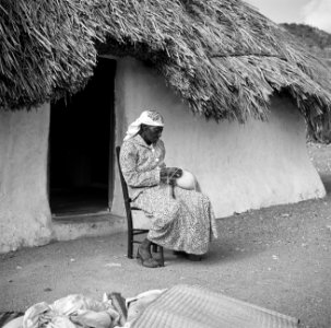 Vrouw bezig met het maken van een strooien hoed in het dorp Lagoen op Curaçao, Bestanddeelnr 252-7484